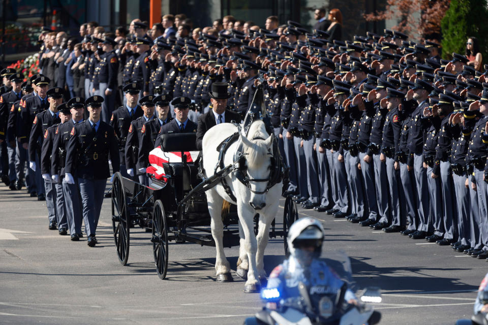 A funeral caisson transports the casket of Raleigh Police Officer Gabriel Torres to Cross Assembly Church in Raleigh, N.C. for his funeral Saturday, Oct. 22, 2022. Torres, a Raleigh police officer and former U.S. Marine, was inside his personal vehicle and about to leave for work when authorities said he was shot by a 15-year-old boy wearing camouflage clothing and firing a shotgun. (Ethan Hyman/The News & Observer via AP)