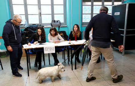 A voter with a dog arrives to cast his vote for the European Parliament elections at a polling station in Rome, Italy May 26, 2019. REUTERS/Remo Casilli