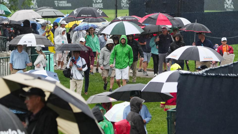 Golf fans pulled out their umbrellas and walked off the course during a weather delay in the PGA Championship practice round at the Valhalla Golf Course in Louisville, Ky. on May. 14, 2024.