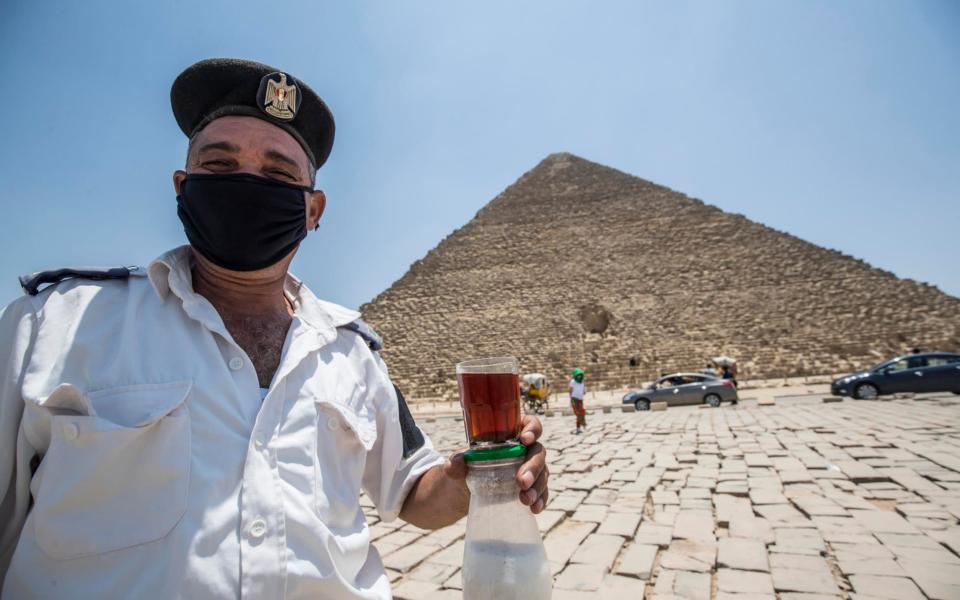 A mask-clad Egyptian policeman on duty at the Giza Pyramids - Khaled Desouki