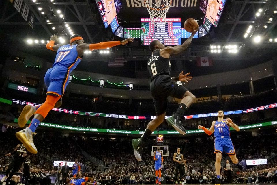 Milwaukee Bucks' Eric Bledsoe shoots past Oklahoma City Thunder's Dennis Schroder during the second half of an NBA basketball game Friday, Feb. 28, 2020, in Milwaukee. (AP Photo/Morry Gash)