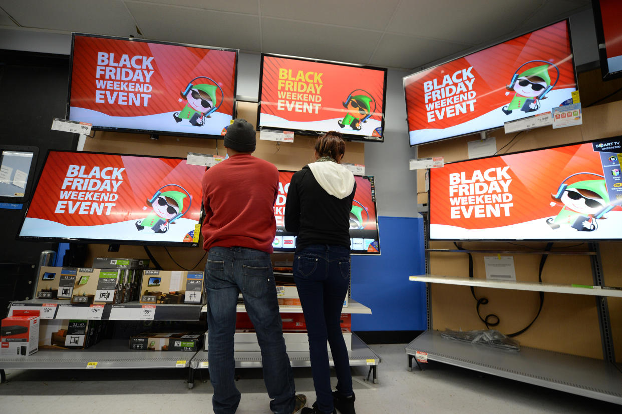 Shoppers consider televisions for sale at the Walmart in the Crenshaw district of Los Angeles on Black Friday, November 29, 2013.   AFP PHOTO / Robyn Beck        (Photo credit should read ROBYN BECK/AFP/Getty Images)