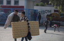 Palestinians take shelter provided by the U.N. at a school after fleeing their homes from the overnight Israeli heavy missile strikes on their neighborhoods in the outskirts of Gaza City, Friday, May 14, 2021. (AP Photo/Khalil Hamra)