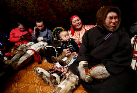 Memebers of indigenous community "Yamb To" (Long Lake) sit inside a tent during the early voting in remote areas ahead of the presidential election, at a reindeer camping ground, about 450 km northeast of Naryan-Mar, in Nenets Autonomous District, Russia, March 1, 2018. REUTERS/Sergei Karpukhin