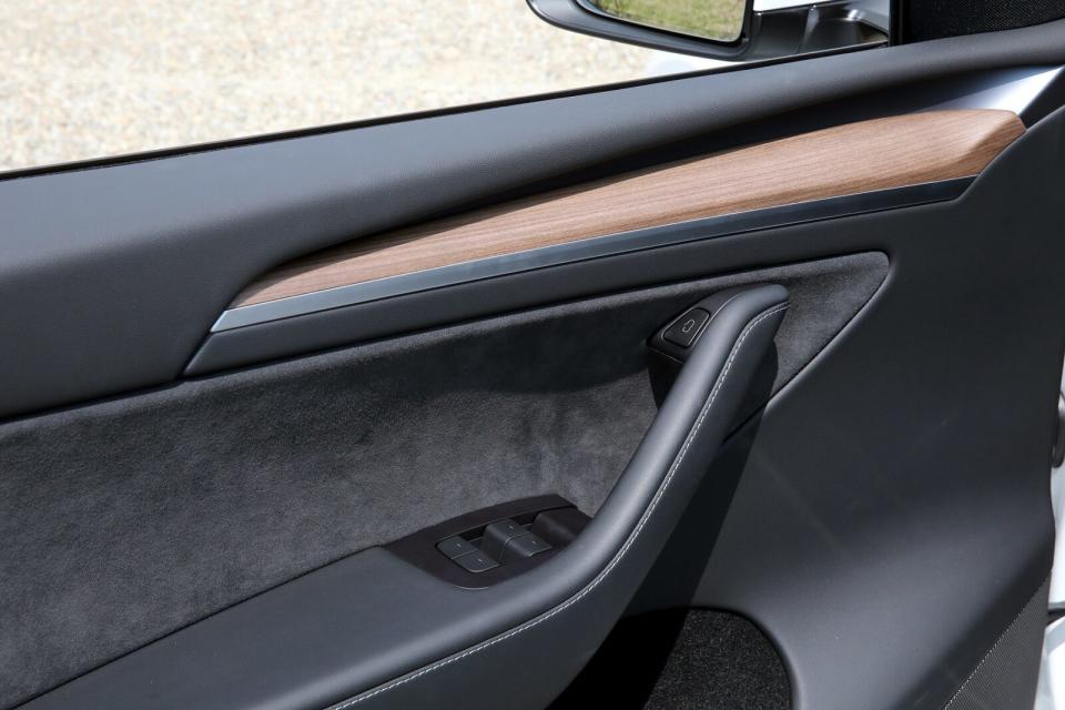 Long Range車型採用視覺感受溫潤的木質飾板作為車室點綴，門把頂端則整合車門電磁開關。