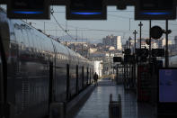 A railway employee stands next to a high-speed train at the Gare St-Charles station in Marseille, southern France, Sunday, Dec. 8, 2019, on the fourth day of nationwide strikes that disrupted weekend travel around France. (AP Photo/Daniel Cole)