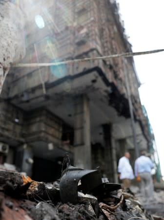 Belongings of victims are seen amid rubble in front of the damaged facade of the National Cancer Institute after an overnight fire from a blast, in Cairo