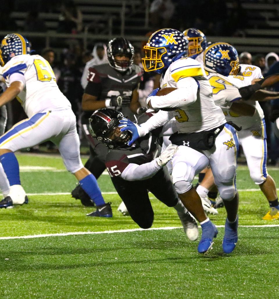 West Muskingum's Rashid SeSay stiff arms a Harvest Prep defender.