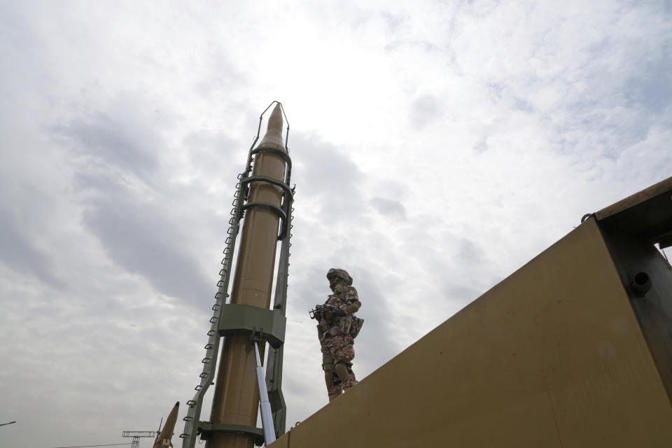 A member of the Revolutionary Guard stands in front of Shahab-3 missile which is displayed during the annual pro-Palestinian Al-Quds, or Jerusalem, Day rally in Tehran, Iran, Friday, April 29, 2022. Iran does not recognize Israel and supports Hamas and Hezbollah, militant groups that oppose it. (AP Photo/Vahid Salemi)