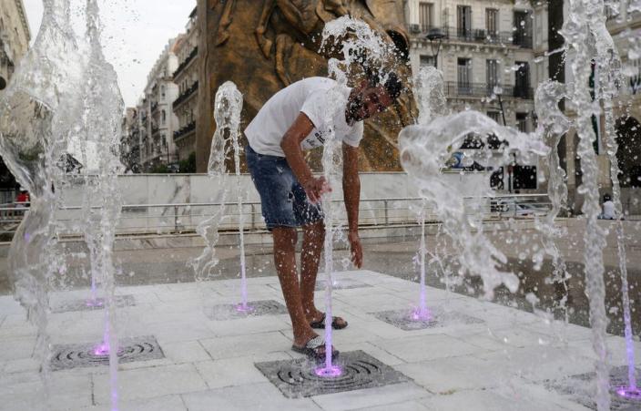 A man cools off at a splash pad.