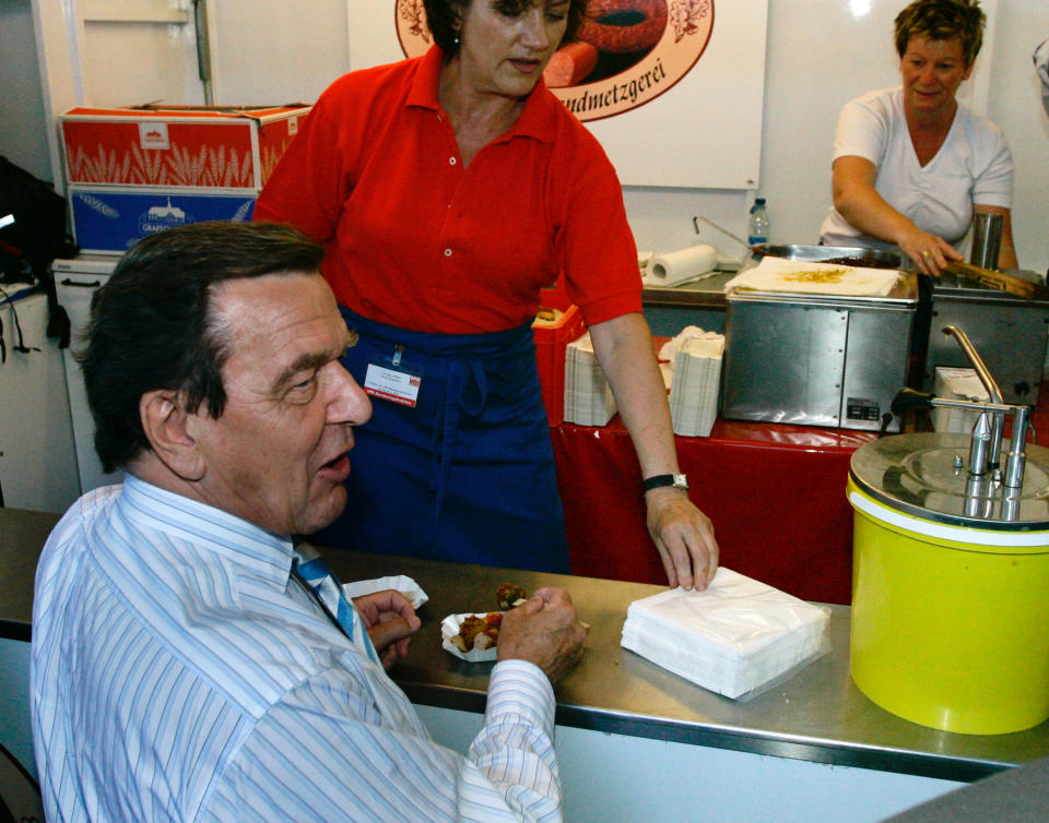 Gerhard Schröder isst auf dem Sommerfest der SPD-Fraktion 2005 eine Currywurst (Bild: Carsten Koall/Getty Images)