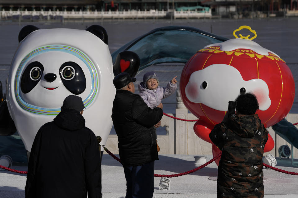 A child reacts near the Winter Olympics and Paralympics mascots, Bing Dwen Dwen, and Shuey Rhon Rhon along a lake in Beijing, China, Monday, Feb. 7, 2022. As China gets back to business after a muted Chinese New Year holiday that coincided with the start of the pandemic-restricted Beijing Olympic Winter Games, the feeling inside and out of the bubble in this auspicious Year of the Tiger is that festivities for the most sacred and important holiday for the country were limited and underwhelming. (AP Photo/Ng Han Guan)