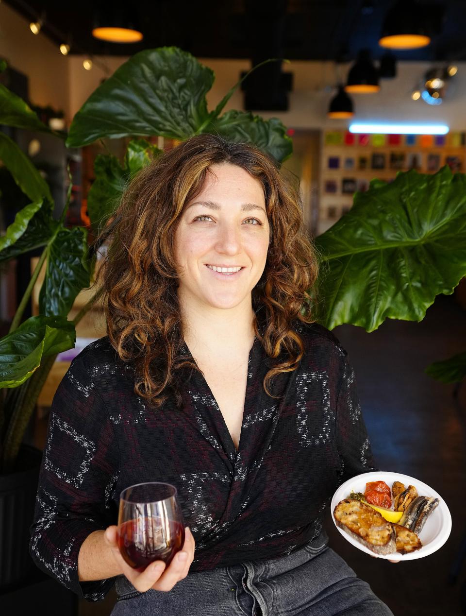 Chef Dana Arbel poses with her Boquerones dish and a glass of Dreamboat field blend wine at Central Records Wine Cafe in downtown Phoenix on Feb. 15, 2023.