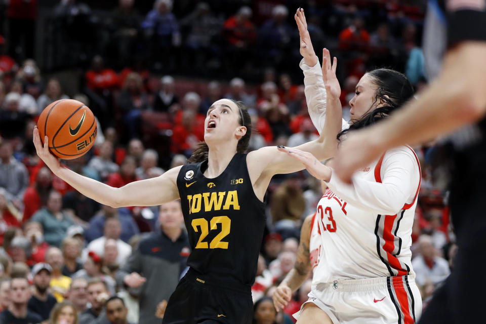 Iowa guard Caitlin Clark, left, goes in for a basket as Ohio State forward Rebeka Mikulasikova defends during the first half of an NCAA college basketball game at Value City Arena in Columbus, Ohio, Monday, Jan. 23, 2023. (AP Photo/Joe Maiorana)