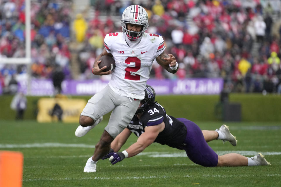 Ohio State wide receiver Emeka Egbuka, left, runs for a touchdown past Northwestern linebacker Xander Mueller during the first half of an NCAA college football game, Saturday, Nov. 5, 2022, in Evanston, Ill. (AP Photo/Nam Y. Huh)