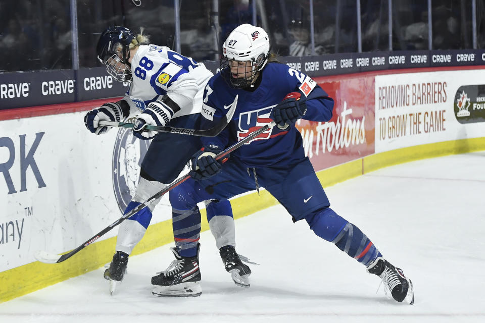United States forward Taylor Heise, right, fights for the puck against Finland defensewoman Ronja Savolainen during the first period in the semifinals at the IIHF women's world hockey championships Saturday, April 13, 2024, in Utica, N.Y. (AP Photo/Adrian Kraus)