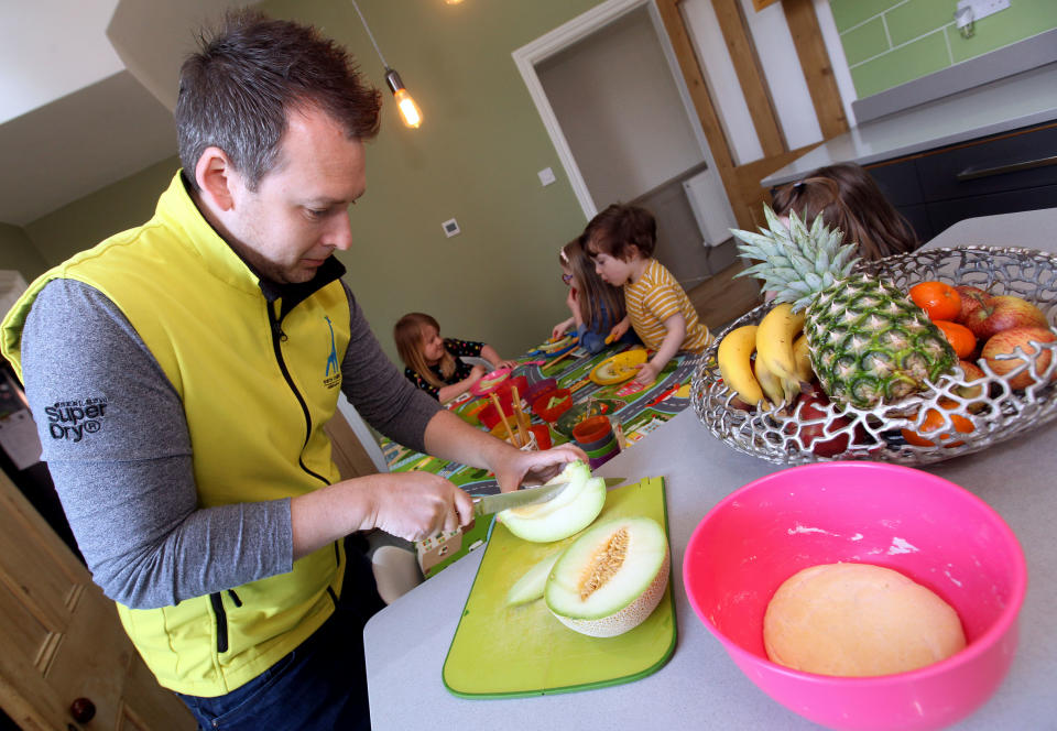 Sam Mills cutting up up fruit for the children he looks after. [Photo: Caters]