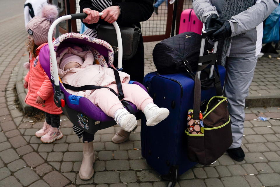 A baby sleeps in a car seat, after crossing the border to flee violence in Ukraine with her mother, at the border crossing in Medyka, Poland, February 25, 2022. REUTERS/Bryan Woolston