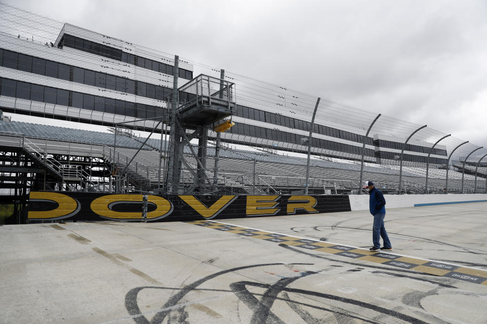 Mike Tatoian, president and CEO of Dover International Speedway, walks near the finish line while waiting for a news conference at the track, Monday, April 27, 2020, in Dover, Del. The track was scheduled to host a NASCAR auto race this weekend, but due to the COVID-19 outbreak, the race is bring run virtually on NASCAR's iRacing circuit. (AP Photo/Matt Slocum)