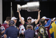 Colorado Avalanche president and governor Josh Kroenke lifts the Stanley Cup during a rally outside the City/County Building for the NHL hockey champions after a parade through the streets of downtown Denver, Thursday, June 30, 2022. (AP Photo/David Zalubowski)