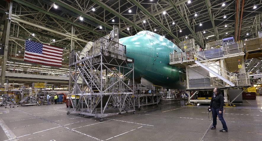 FILE - In this file photo taken Wednesday, May 29, 2013, a visitor looks up at a Boeing 747 jet being assembled at the company's production plant in Everett, Wash. For decades, the Boeing’s 747 was the Queen of the Skies. But the glamorous double-decker jumbo jet that revolutionized air travel and shrunk the globe could be nearing the end of the line. (AP Photo/Elaine Thompson, File)