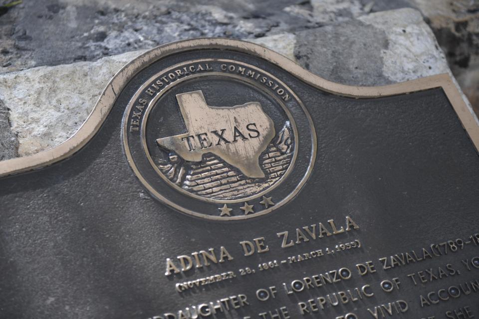 A Texas Historical Commission plaque inscribed with Adina De Zavala's biography sits in front of the Alamo.