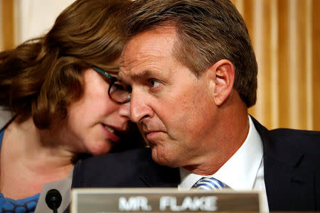 An aide speaks to U.S. Senator Jeff Flake (R-AZ) while he participates as Defense Secretary James Mattis and Secretary of State Rex Tillerson testify about authorizations for the use of military force before the Senate Foreign Relations Committee on Capitol Hill in Washington, U.S. October 30, 2017. REUTERS/Jonathan Ernst