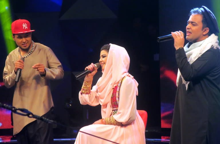 Young Afghan singer Zulala Hashemi performs alongside competitors Sayed Jamal Mubarez (L) and Babak Mohammadi during the television music competition 'Afghan Star', in Kabul