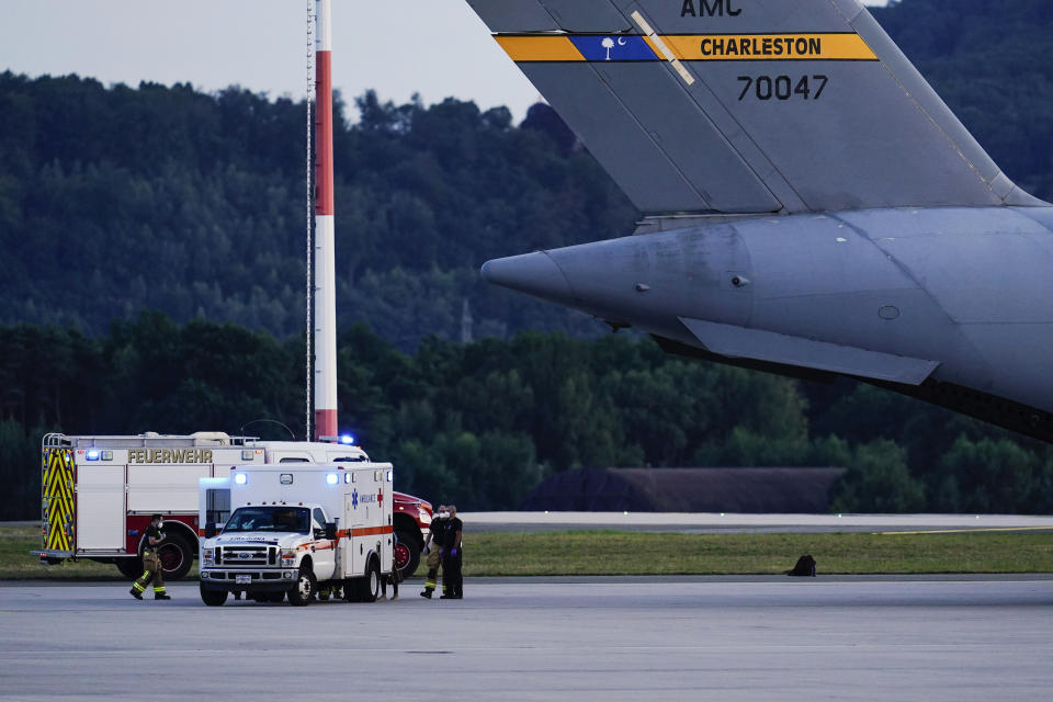 An ambulance stands next to a transport plane carrying people flown out of Afghanistan at Ramstein Air Base, in Ramstein-Miesenbach, Germany, Friday, Aug. 2021. (Uwe Anspach/dpa via AP)