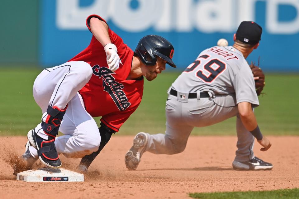 Cleveland's Bradley Zimmer (4) slides into second base with a double as Detroit Tigers shortstop Zack Short (59) waits for the relay throw on Aug. 8, 2021, in Cleveland.