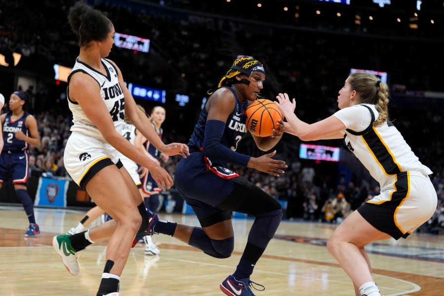 UConn forward <a class="link " href="https://sports.yahoo.com/ncaaw/players/64072/" data-i13n="sec:content-canvas;subsec:anchor_text;elm:context_link" data-ylk="slk:Aaliyah Edwards;sec:content-canvas;subsec:anchor_text;elm:context_link;itc:0">Aaliyah Edwards</a> (3) fights for a loose ball with Iowa forward Hannah Stuelke, left, and guard <a class="link " href="https://sports.yahoo.com/ncaaw/players/56890/" data-i13n="sec:content-canvas;subsec:anchor_text;elm:context_link" data-ylk="slk:Kate Martin;sec:content-canvas;subsec:anchor_text;elm:context_link;itc:0">Kate Martin</a>, right, during the first half of a Final Four college basketball game in the women’s NCAA Tournament, Friday, April 5, 2024, in Cleveland. (AP Photo/Morry Gash)