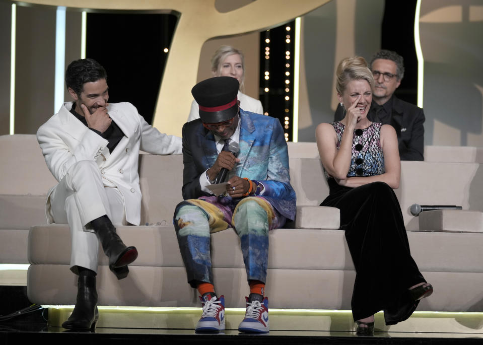 Jury president Spike Lee, bottom center, almost announces 'Titane' as the winner of the Palme d'Or for the second time as fellow jury members Tahar Rahim, bottom left, Jessica Hausner, back left, Melanie Laurent, bottom right, and Kleber Mendonca Filho, back left, look on during the awards ceremony at the 74th international film festival, Cannes, southern France, Saturday, July 17, 2021. (AP Photo/Vadim Ghirda)