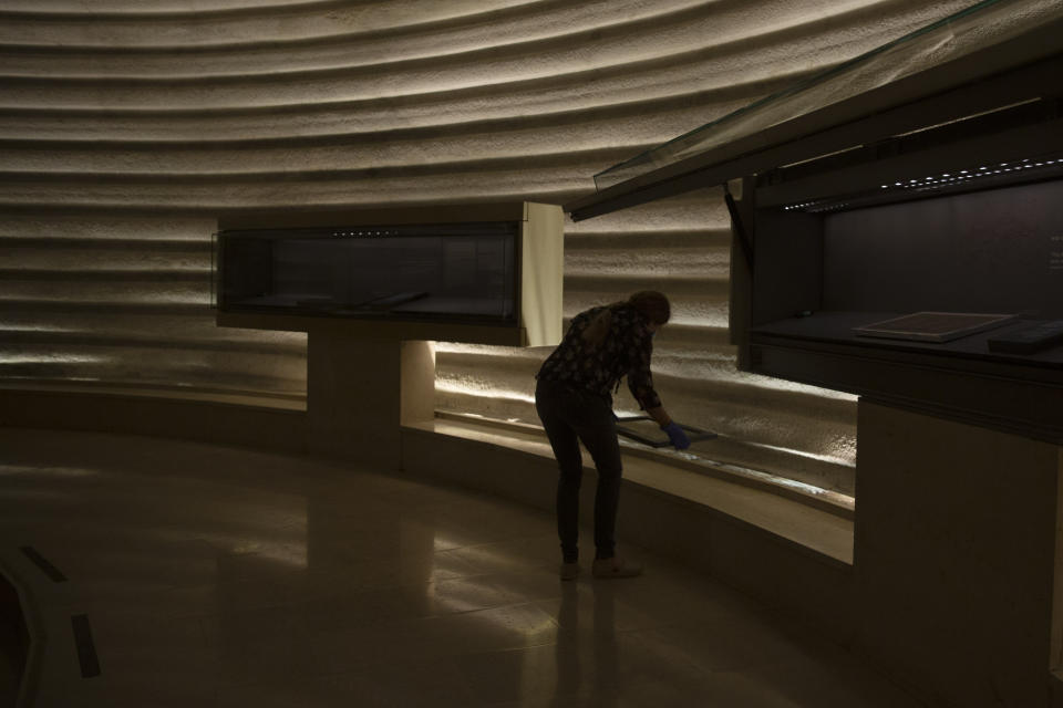 Hagit Maoz, curator of the Dead Sea Scrolls at the Shrine of the Book in the Israel Museum, makes final preparations ahead of reopening following five months of closure due to the coronavirus pandemic, in Jerusalem, Tuesday, Aug. 11, 2020. The Israel Museum, the country's largest cultural institution, is returning the priceless Dead Sea scrolls and other treasured artworks to its galleries ahead of this week's reopening to the public. (AP Photo/Maya Alleruzzo)