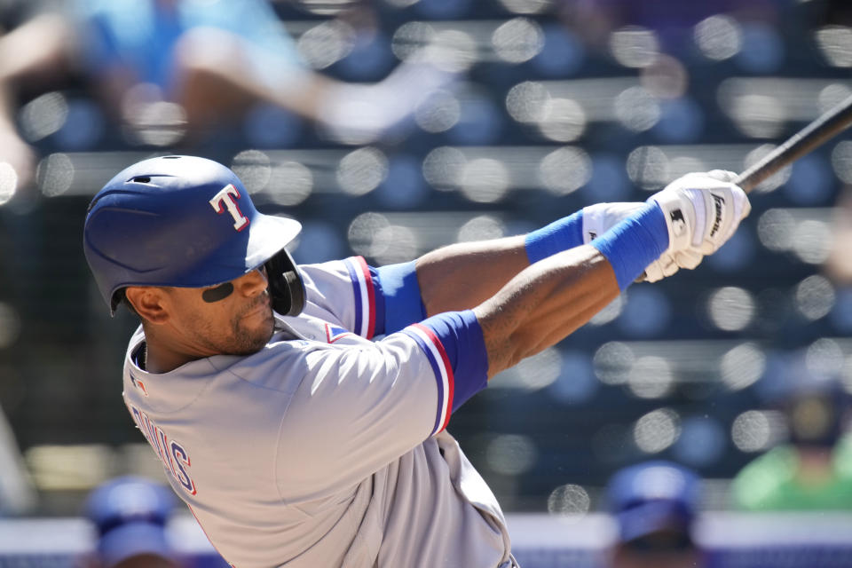 Texas Rangers' Khris Davis connects for a two-run home run off Colorado Rockies relief pitcher Jordan Sheffield in the seventh inning of a baseball game Thursday, June 3, 2021, in Denver. (AP Photo/David Zalubowski)