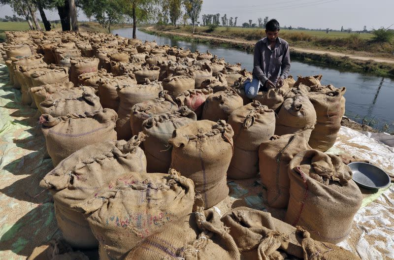 A worker packs a sack filled with rice on the outskirts of Ahmedabad