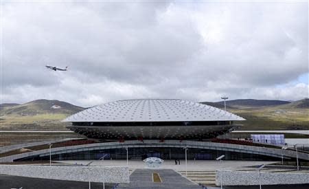 A plane takes off from the terminal of Daocheng Yading Airport in Daocheng county of Garze Tibetan Autonomous Prefecture, Sichuan province September 16, 2013. The airport, at 4,411 metres (14,472 feet) above sea level, surpassed the Qamdo Bangda Airport which has an altitude of 4,334 metres (14,219 feet), and became the highest airport in the world after its inauguration on Monday, according to local media. REUTERS/China Daily