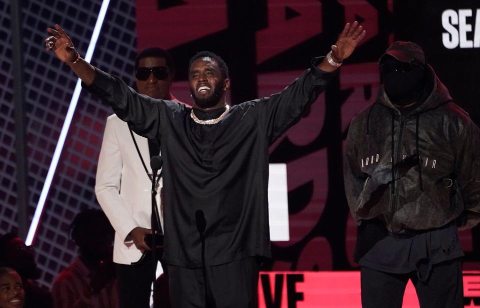 Sean "Diddy" Combs accepts the lifetime achievement award at the BET Awards, at the Microsoft Theater in Los Angeles. Babyface and Kanye West, also known as Ye, look on from back left 2022 BET Awards - Show, Los Angeles, United States - 26 Jun 2022