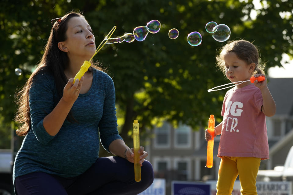 Claire Reagan plays with her daughter Abbie, 3, Monday, Sept. 21, 2020, outside her home in Olathe, Kan. Reagan is keeping her son Evan, age 5, from starting kindergarten and her daughter from preschool due to concerns about the coronavirus pandemic. (AP Photo/Charlie Riedel)