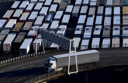 A lorry is driven past dozens of others parked after traveling by ferry between Britain and France at the Port of Dover