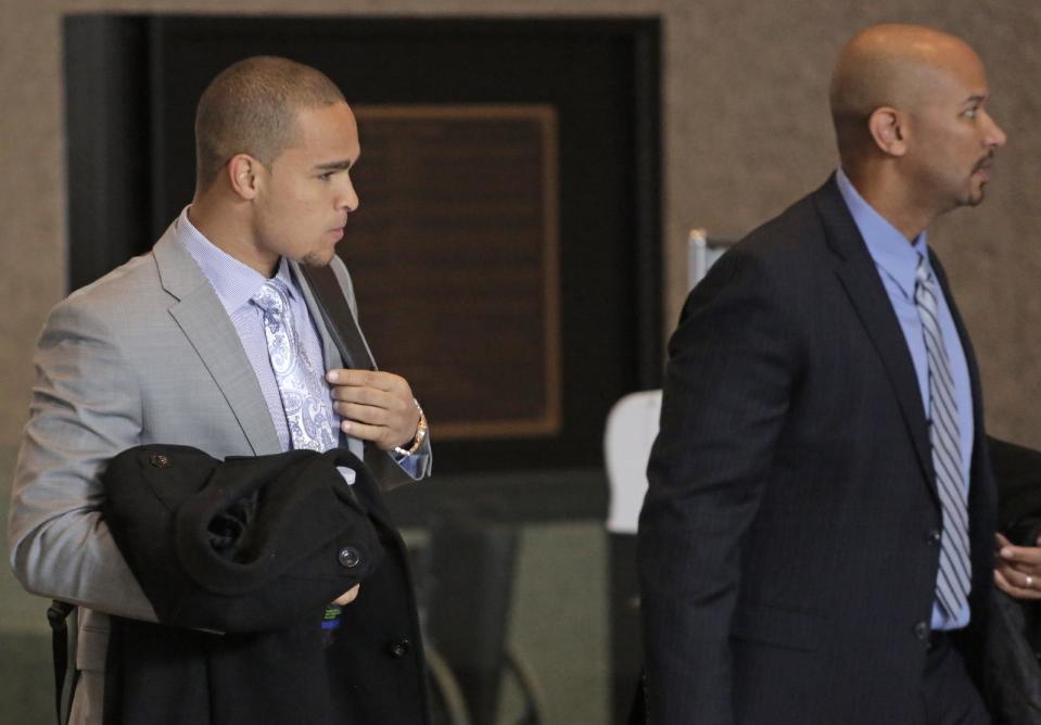 College Athletes Players Association designated president Ramogi Huma, right, and Northwestern University Wildcats' outgoing senior quarterback Kain Colter make their way to the beginning of three days of hearings before the National Labor Relations Board Tuesday, Feb. 18, 2014, in Chicago. The NLRB is scheduled to begin witness testimony on whether to approve a bid by Northwestern University football players who are trying to unionize. Colter is among the key witnesses in the case. (AP Photo/M. Spencer Green)