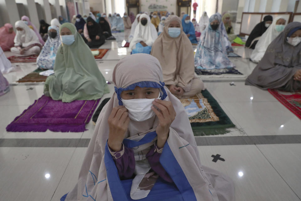 Muslims wearing face masks to curb the spread of coronavirus attend during an Eid al-Adha prayer at Zona Madina mosque in Bogor, Indonesia, Tuesday, July 20, 2021. Muslims across Indonesia marked a grim Eid al-Adha festival for a second year Tuesday as the country struggles to cope with a devastating new wave of coronavirus cases and the government has banned large gatherings and toughened travel restrictions. (AP Photo/Tatan Syuflana)