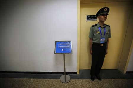 A soldier of the People's Liberation Army (PLA) stands in front of a laboratory of angel electronic techniques during an organised media tour at a PLA engineering academy in Beijing July 22, 2014. REUTERS/Petar Kujundzic