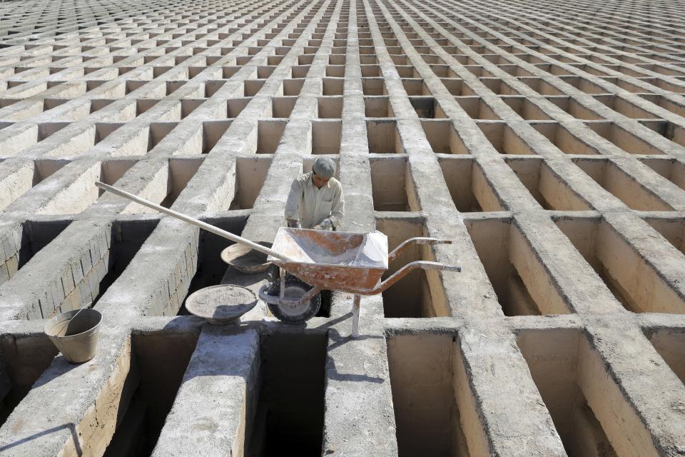 FILE - In this Sunday, Nov. 1, 2020 file photo, a cemetery worker prepares new graves at the Behesht-e-Zahra cemetery on the outskirts of the Iranian capital, Tehran, Iran. Though Iran faces crushing U.S. sanctions, there still remain ways for Tehran to obtain coronavirus vaccines as it suffers the Mideast's worst outbreak of the pandemic. (AP Photo/Ebrahim Noroozi, File)