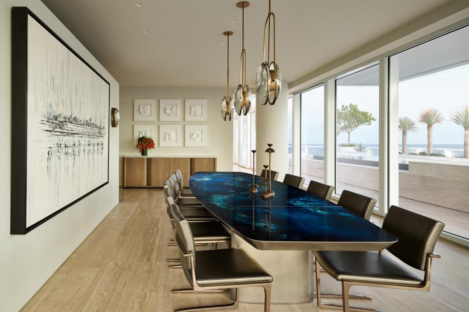 Located in Miami’s The Surf Club, a dining room designed by House of Hunt features a statement-making blue dining table by Based Upon, echoing the ocean views outdoors. An Alison Berger Glassworks light fixture hangs above.