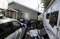 Vehicles are parked outside the home of Paige A. Thompson, who uses the online handle "erratic," Wednesday, July 31, 2019, in Seattle. Thompson was taken into custody Monday at her home and has been charged with computer fraud and abuse in connection with hacking data from more than 100 million Capital One credit holders or applicants. (AP Photo/Ted S. Warren)