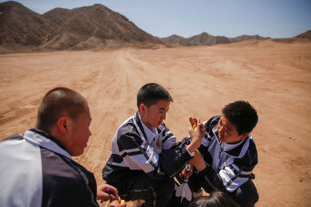 Students build a toy rocket at the C-Space Project Mars simulation base in the Gobi Desert outside Jinchang, Gansu Province, China, April 17, 2019. REUTERS/Thomas Peter