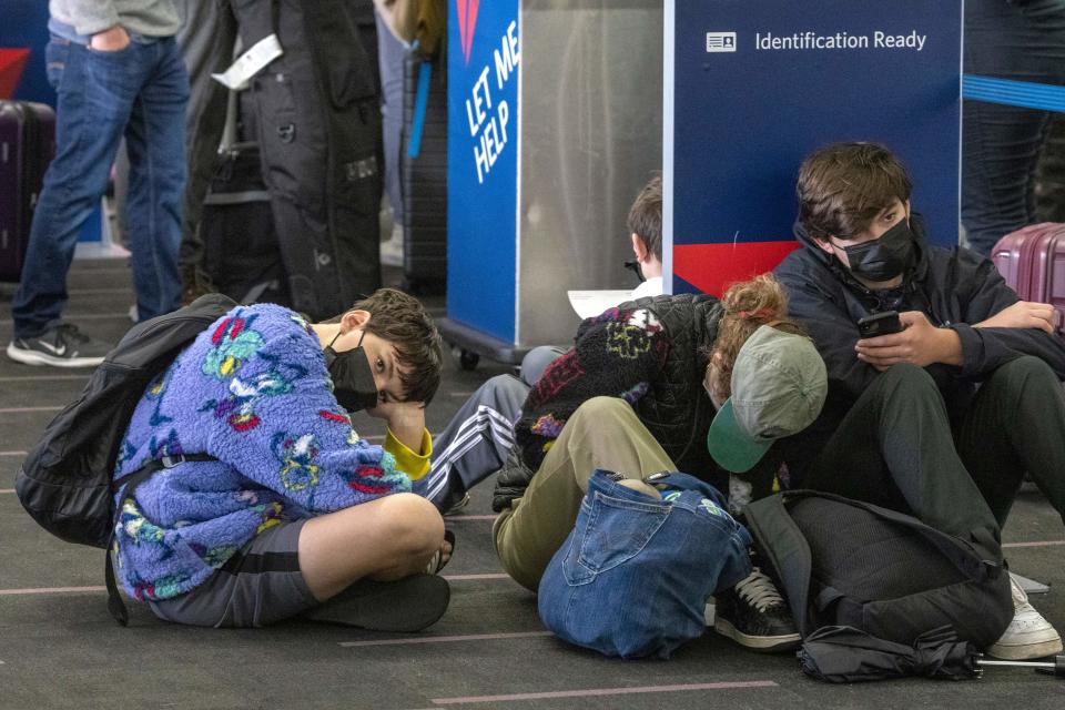 Travelers wait at Los Angeles International Airport on Dec. 24, 2021, amid thousands of flight cancellations and delays tied to omicron cases among staff and other issues.