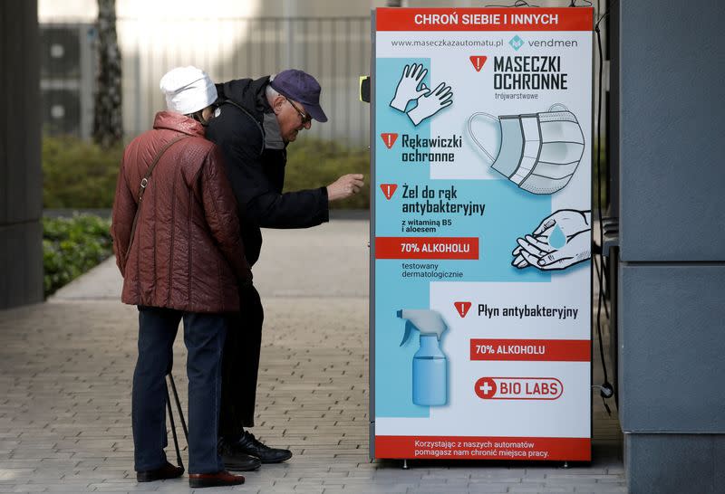 People use a vending machine for face masks, gloves and sanitiser during the coronavirus disease (COVID-19) outbreak, in Warsaw