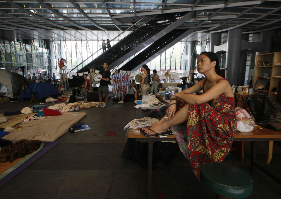 A protester sits on a table as bailiffs evict Hong Kong's Occupy activists from a public space underneath HSBC's Asian headquarters Tuesday, Sept. 11, 2012. The protesters had ignored a court order requiring them to leave the site by Aug. 27. (AP Photo/Kin Cheung)