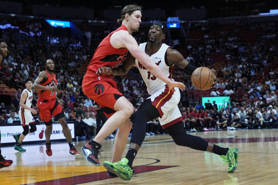 Toronto Raptors forward Kelly Olynyk (41) defends Miami Heat center Bam Adebayo (13) during the first half of an NBA basketball game, Friday, April 12, 2024, in Miami. (AP Photo/Marta Lavandier)